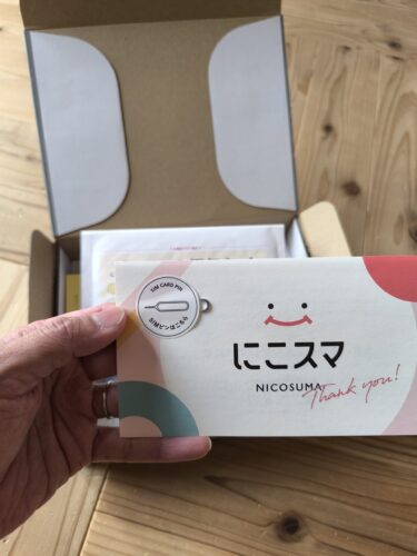 にこスマの中古スマホに同梱されているサンキューカードとSIMピンの写真。初期設定で必ず必要になるSIMピンが分かりやすく付属しており、初めて中古スマホを買う人でも到着後すぐにSIMの入れ替えができる親切なサービス