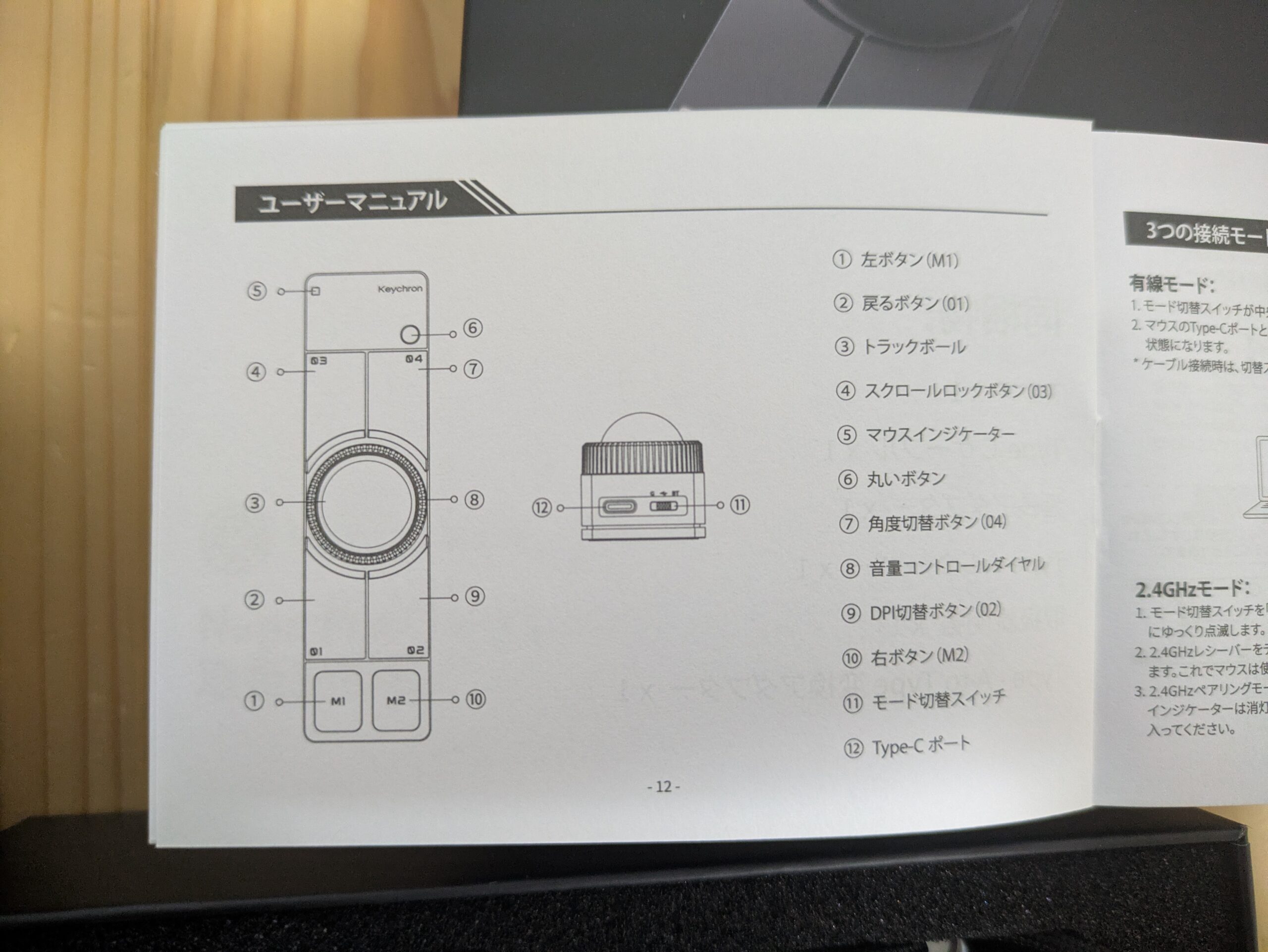 Keychron Nape Proのユーザーマニュアルを開いた写真。トラックボール、M1・M2ボタン、戻るボタン、スクロールロックボタン、DPI切替ボタン、音量コントロールダイヤル、Type-Cポートなど、各部の名称が図解で説明されている。